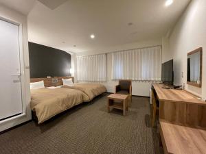 a hotel room with a bed and a desk at Kusatsu Daiichi Hotel in Kusatsu