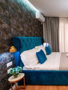 a blue bed with a blue headboard in a room at Rama's Hotel in Tirana