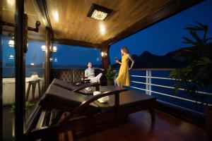 a woman in a yellow dress standing on a balcony at V'Spirit Cruise in Ha Long