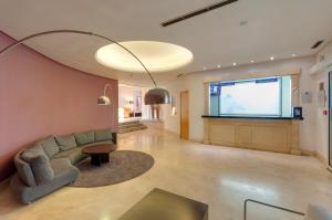 a living room with a couch and a large screen at Gran Hotel Los Angeles in Getafe