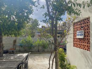 a sign on the side of a building next to a tree at Homestay Miền Biển Vĩnh Hy 2 in Vĩnh Hy