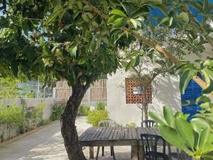 une table et des chaises en bois sous un arbre dans l'établissement Homestay Miền Biển Vĩnh Hy 2, à Vĩnh Hy