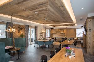 un restaurante con techos de madera, mesas y sillas en LODGE HOTEL Winterberg, en Winterberg