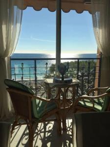 een balkon met een tafel en stoelen en de oceaan bij Victoria bilocale centro città e vista mare in Menton