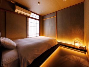 A bed or beds in a room at Kurofune Hotel