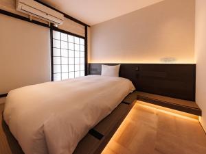 A bed or beds in a room at Kurofune Hotel