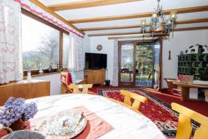 a living room with a table and chairs and a large window at Ferienhaus Hölzl 