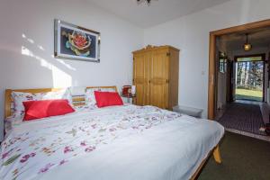 a bedroom with a large white bed with red pillows at Ferienhaus Hölzl 