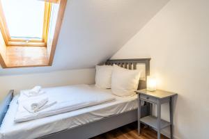 ein kleines Schlafzimmer mit einem Bett und einem Fenster in der Unterkunft Freidorf in Rettenberg