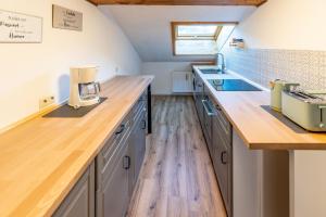 eine Küche mit Arbeitsflächen aus Holz und Holzböden in der Unterkunft Freidorf in Rettenberg
