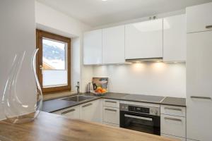 a kitchen with white cabinets and a wooden counter top at Glückspilz in Obermaiselstein
