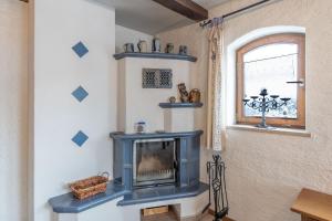 a living room with a blue fireplace and a window at Meggis Bergblick in Bolsterlang