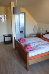 a bedroom with a bed with pink towels on it at Pension Lotte in Kühlungsborn