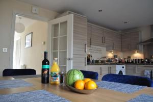 a table with a bowl of fruit and a bottle of wine at Beaney View House - Modern, Spacious 4 Bedrooms Ensuites House with Free Wifi and Parkings in Swindon