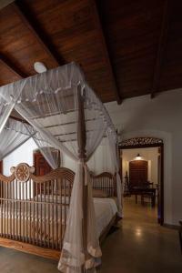 ワッタラにあるWattala Villa- The Guardian Bungalowのベッドルーム(天蓋付きベッド、ベビーベッド付)