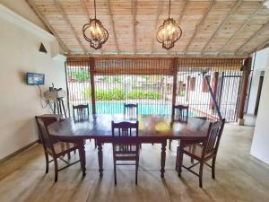 jadalnia z drewnianym stołem i krzesłami w obiekcie Wattala Villa- The Guardian Bungalow w mieście Wattala