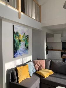 sala de estar con sofá gris y almohadas coloridas en VILLA MOANA en Andernos-les-Bains