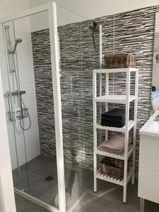 łazienka z prysznicem i białą półką w obiekcie VILLA MOANA w mieście Andernos-les-Bains