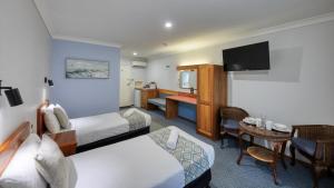 a hotel room with a bed and a table at Kempsey Powerhouse Motel in Kempsey