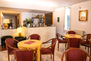 un restaurante con 2 mesas y sillas y un bar en Coccodrillo Hotel & Apartments, en Varazze