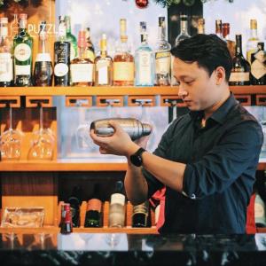 a man standing at a bar with a bartender at 3T Hotel 41 Nguyễn Thái Học- by Bay Luxury in Hanoi