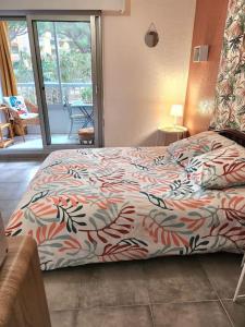 - une chambre avec un lit et une couette colorée dans l'établissement joli studio rénové dans station balnéaire., à Saint-Mandrier-sur-Mer