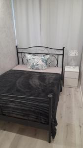 Una cama con marco negro y almohadas. en RoseMarie, en Gotha