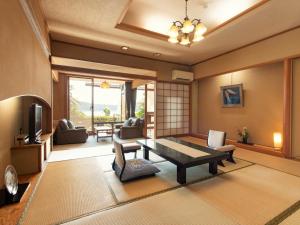 uma sala de estar com uma mesa e um sofá em Kurofune Hotel em Shimoda