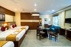 a hotel room with two beds and a table at Safa Residency in Tiruchchirāppalli