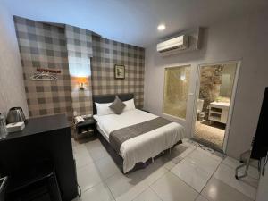a bedroom with a bed and a desk and a window at Boston Plus Hotel in Chiayi City