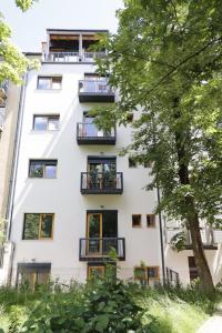 un edificio de apartamentos con balcones y un árbol en JU3 Apartments en Liubliana