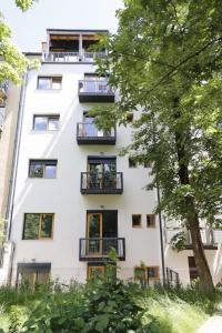 un edificio de apartamentos con balcones y un árbol en JU3 Apartments, en Liubliana