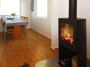 Nørre Hurupにある6 person holiday home in Hadsundのリビングルーム(暖炉、ダイニングテーブル付)
