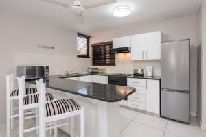 サウスブルームにあるSan Lameer Villa 2510 - 1 Bedroom Classic - 2 pax - San Lameer Rental Agencyの白いキャビネットと黒いカウンタートップを備えたキッチン