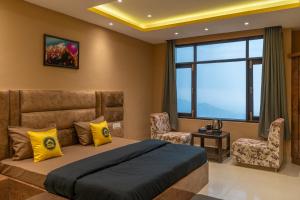 una camera con un letto e due sedie e una finestra di The Hosteller Shimla a Shimla