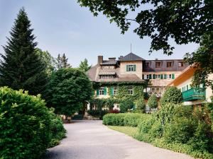 una casa grande con un árbol frente a una entrada en Landhaus zu Appesbach en St. Wolfgang