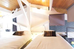 2 łóżka w pokoju z drewnianym sufitem w obiekcie 444 Tourny - Appartement 2 chambres avec ascenseur et Parking w mieście Bordeaux