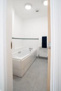 a white bathroom with a tub and a sink at The Amazing Triplex in Sheffield