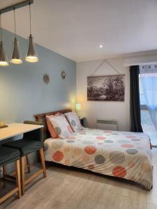 1 dormitorio con cama, mesa y escritorio en Charmant studio entre mer et forêt, en Saint-Mandrier-sur-Mer