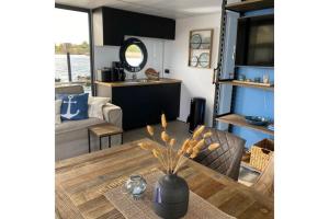 sala de estar con mesa y sofá en Hausboot Fjord Ankerplatz mit Biosauna in Schleswig, en Schleswig