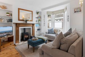 a living room with a couch and a fireplace at Polly's Place, Brixham in Brixham