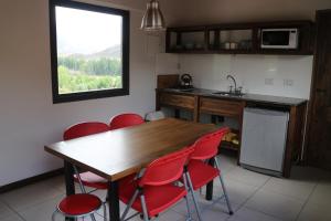 a kitchen with a wooden table and red chairs at Chalet Vista Montana in Potrerillos