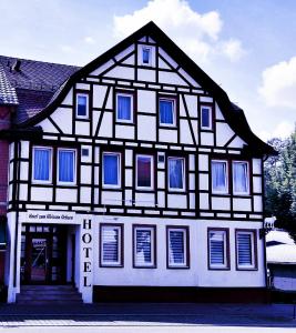 - un bâtiment noir et blanc avec des fenêtres bleues dans l'établissement Hotel zum Weissen Ochsen, à Aalen
