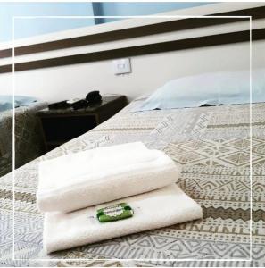 una pila de toallas sentadas encima de una cama en Hotel Germânia Nova Veneza, en Nova Veneza