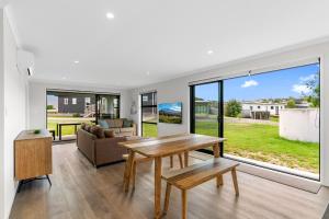 ein Wohnzimmer mit Tisch und Couch in der Unterkunft Sweet and Stylish - Mangawhai Heads Holiday Home in Mangawhai