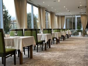 a row of tables and chairs in a restaurant at Apollo Wellness Club in Sângeorgiu de Mureș