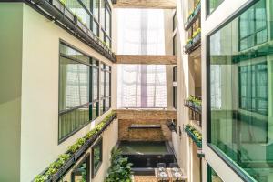 a hallway in a building with windows and plants at Amber Boutique Silom in Bangkok +26 photos