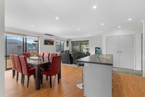 a kitchen and living room with a table and chairs at Summertime Bliss - Mangawhai Heads Holiday Home in Mangawhai