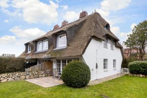 a white house with a thatched roof at Ferienhaus Essex in Keitum