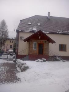 ein Haus mit Schnee auf dem Boden davor in der Unterkunft Hunter 3 in Jugów